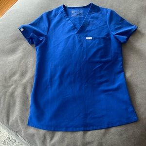 Color: winning blue. Figs one pocket scrub top. Size XS